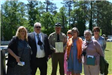 Group of people standing by officer holding plaque