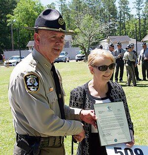 Officer holding plaque next to lady